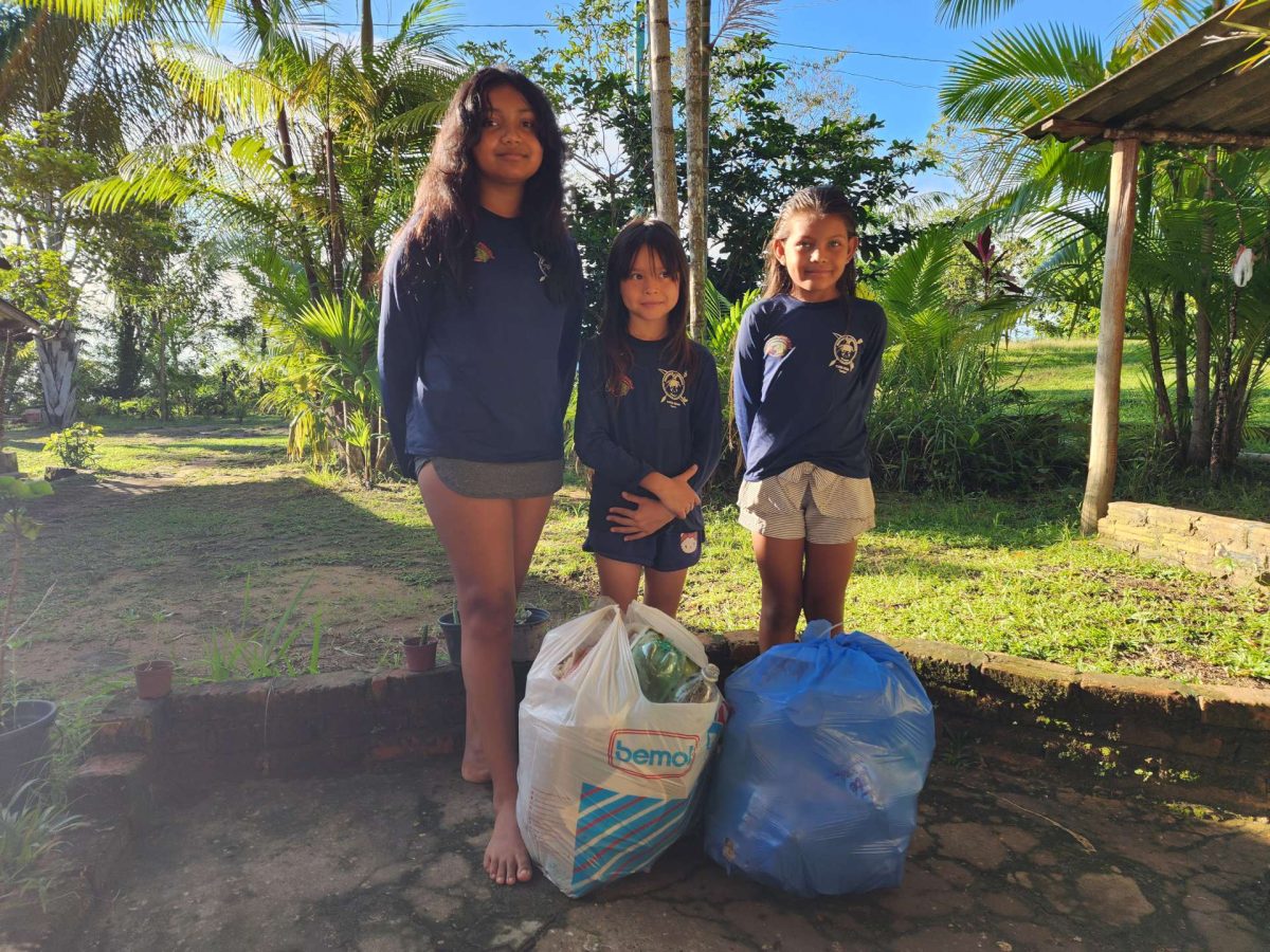 Three kids helping to clean the beach